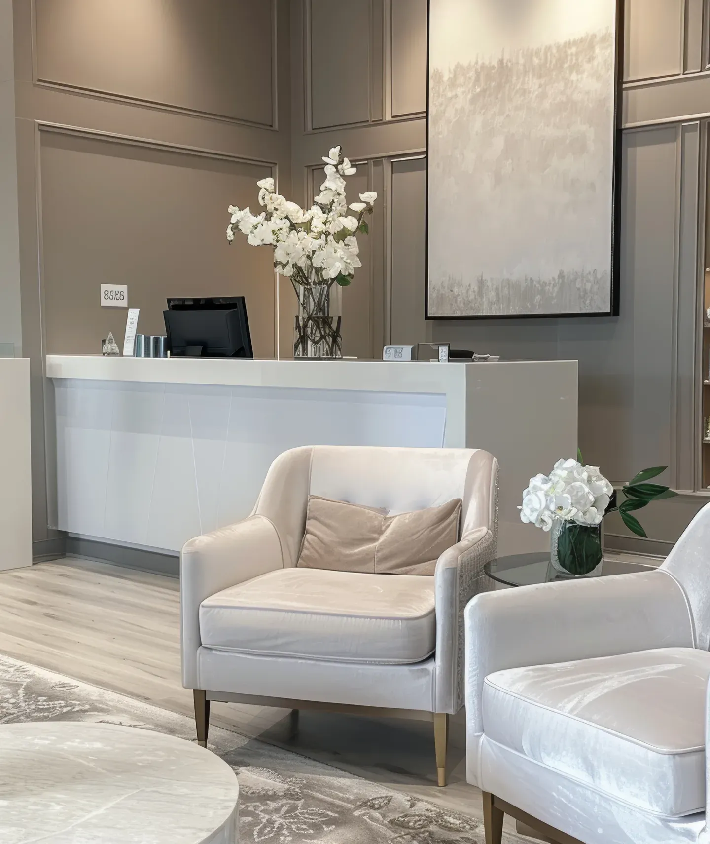 Reception area of a high-end aesthetic clinic with plush chairs, flowers and soft lighting.